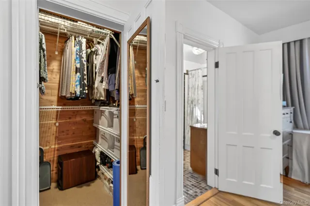 a view of walk in closet with clothes and shoes