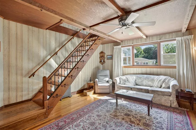 a living room with wooden floor and a dining table