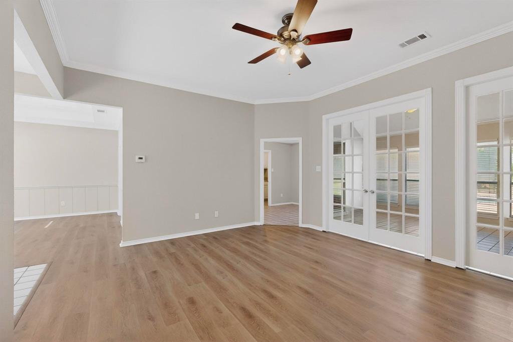 2601 Trail Tree Court Burleson, TX 76028 - Photo 11 of 40 Unfurnished room featuring french doors, a ceiling fan, light wood finished floors, and crown molding