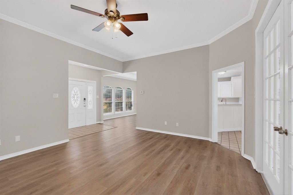 2601 Trail Tree Court Burleson, TX 76028 - Photo 12 of 40 Unfurnished living room featuring a ceiling fan, ornamental molding, and dark wood-type flooring