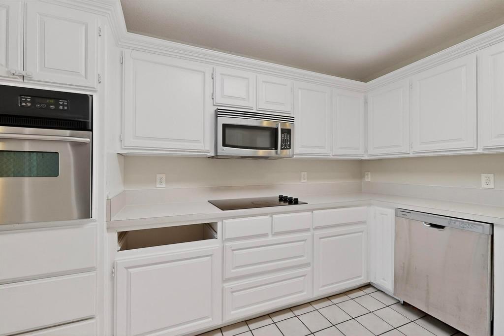 2601 Trail Tree Court Burleson, TX 76028 - Photo 17 of 40 Kitchen featuring stainless steel appliances, light countertops, white cabinets, and light tile patterned floors