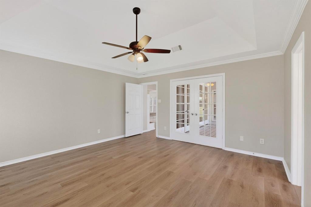2601 Trail Tree Court Burleson, TX 76028 - Photo 22 of 40 Empty room with french doors, a ceiling fan, light wood-style floors, and ornamental molding