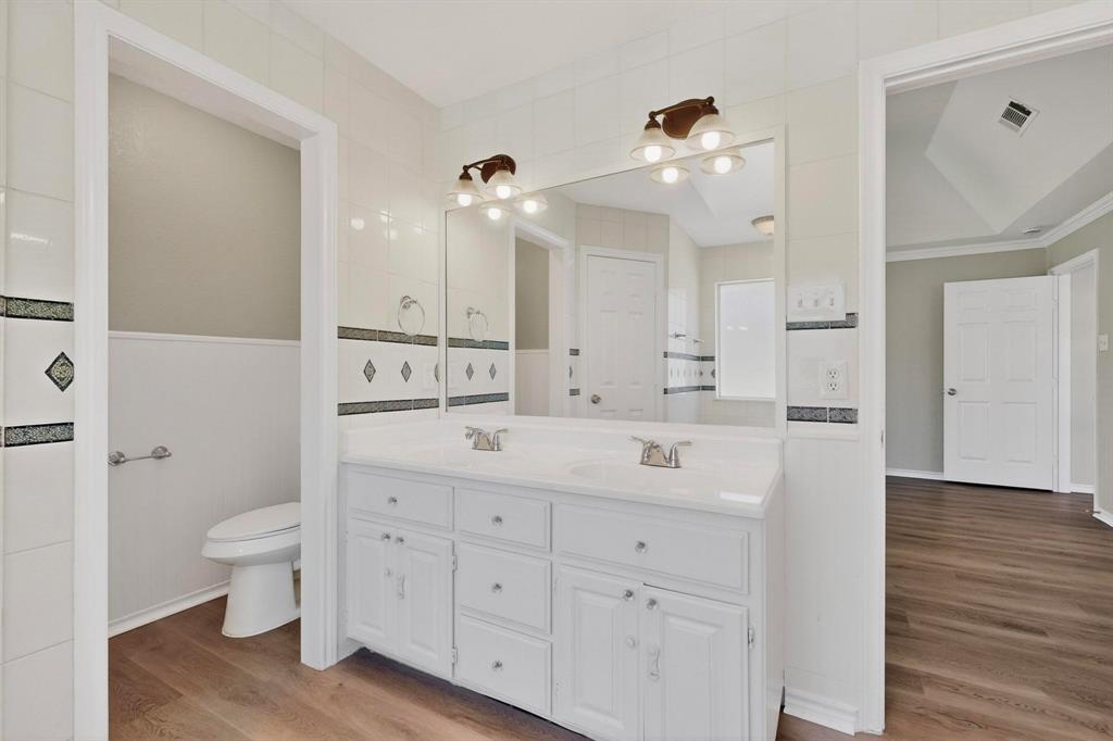 2601 Trail Tree Court Burleson, TX 76028 - Photo 24 of 40 Bathroom featuring double vanity, light wood-type flooring, and tile walls