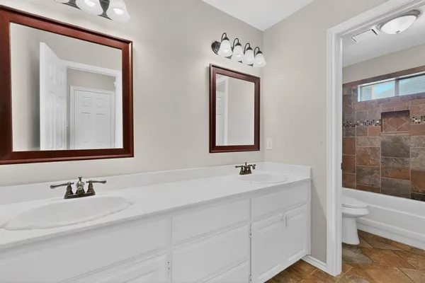 a bathroom with 2 sink and a mirror