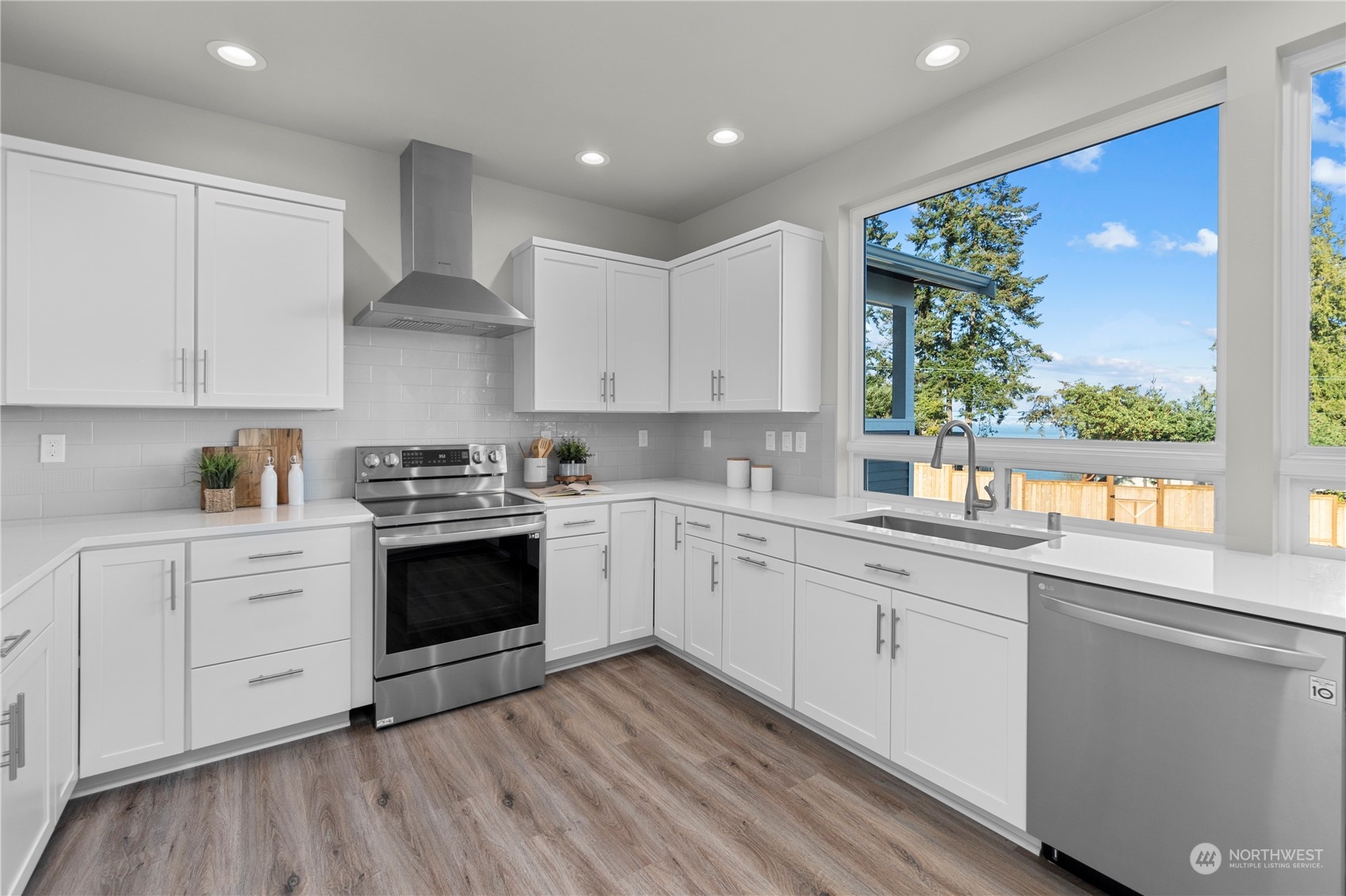 6441 Humphrey Road, Unit 4 Clinton, WA 98236 - Photo 3 of 40 a kitchen with a white cabinets and wooden floor
