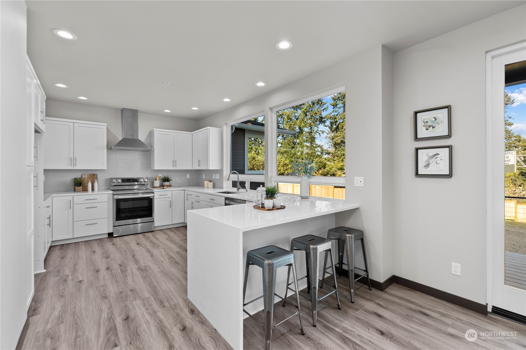 6441 Humphrey Road, Unit 4 Clinton, WA 98236 - Photo 6 of 40 a kitchen with a sink a counter top space a large window and stainless steel appliances