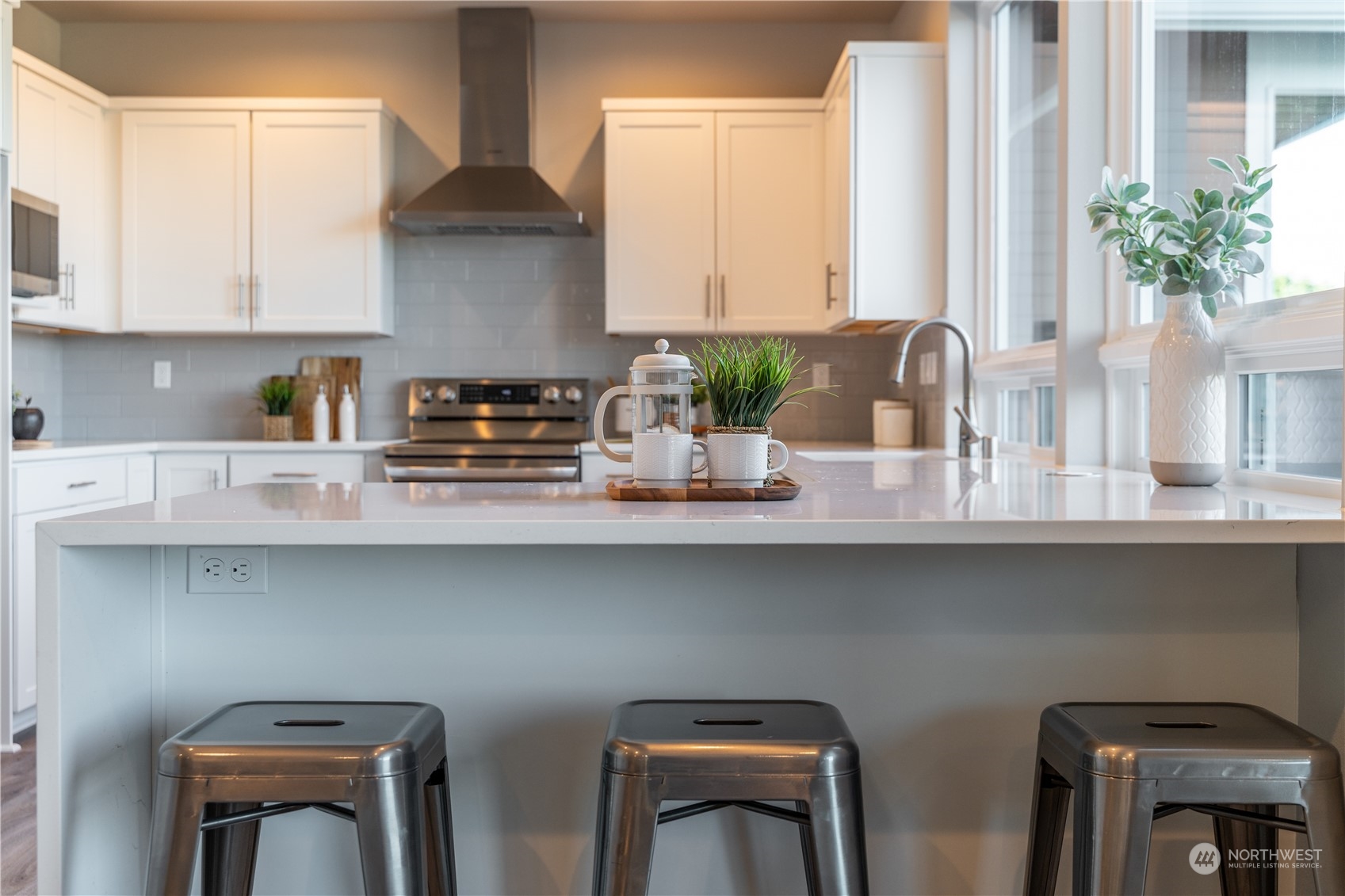 6441 Humphrey Road, Unit 4 Clinton, WA 98236 - Photo 7 of 40 a kitchen with stainless steel appliances a white table and chairs in it