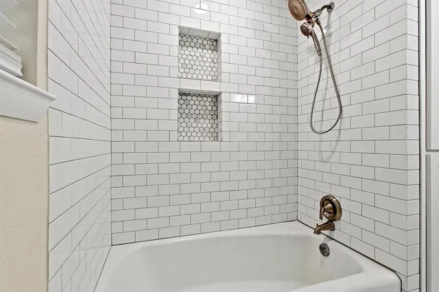 a bathroom with a granite countertop toilet a sink a mirror and a bathtub