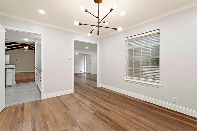 a view of empty room with wooden floor and ceiling fan