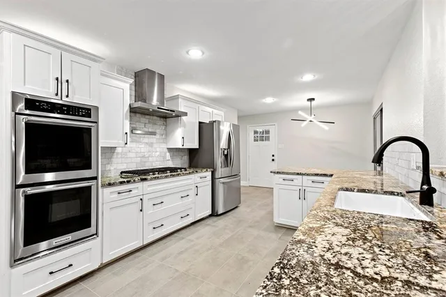a kitchen with stainless steel appliances a stove a sink and a refrigerator