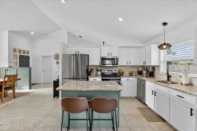 a kitchen with a refrigerator and countertop cabinets