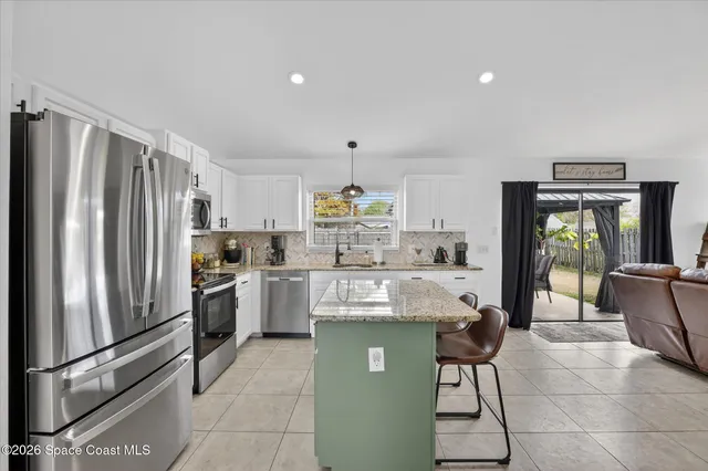 a kitchen with stainless steel appliances kitchen island granite countertop a sink and cabinets