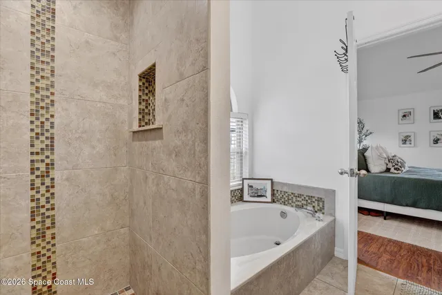 a bathroom with a tub sink and mirror