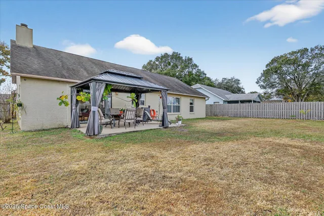 a view of a house with backyard and tree