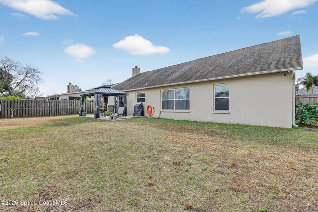 a view of a house with backyard and trees