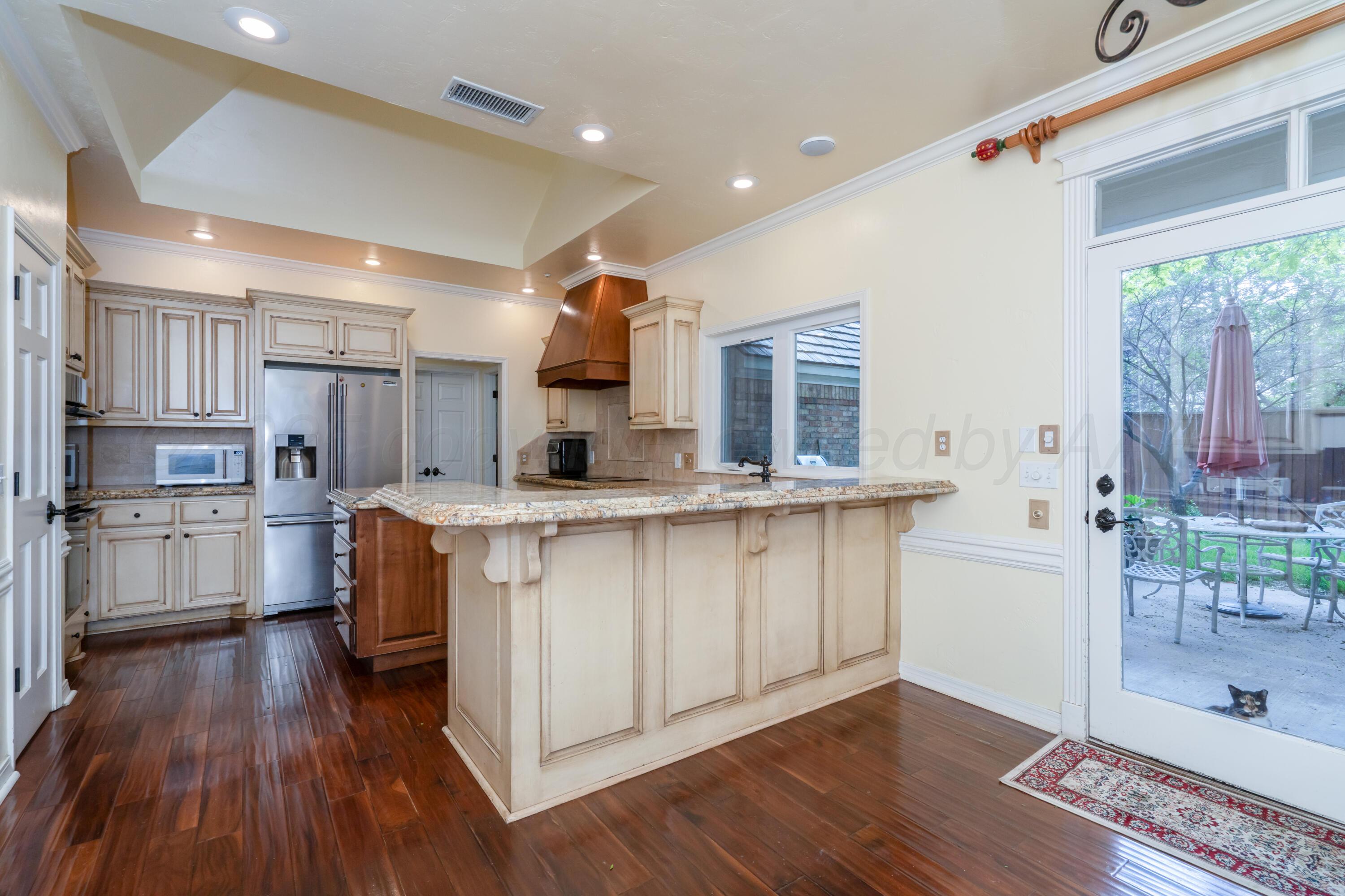 3501 Van Winkle Drive Amarillo, TX 79121 - Photo 13 of 35 a kitchen with stainless steel appliances granite countertop a refrigerator a sink dishwasher a stove and white cabinets with wooden floor