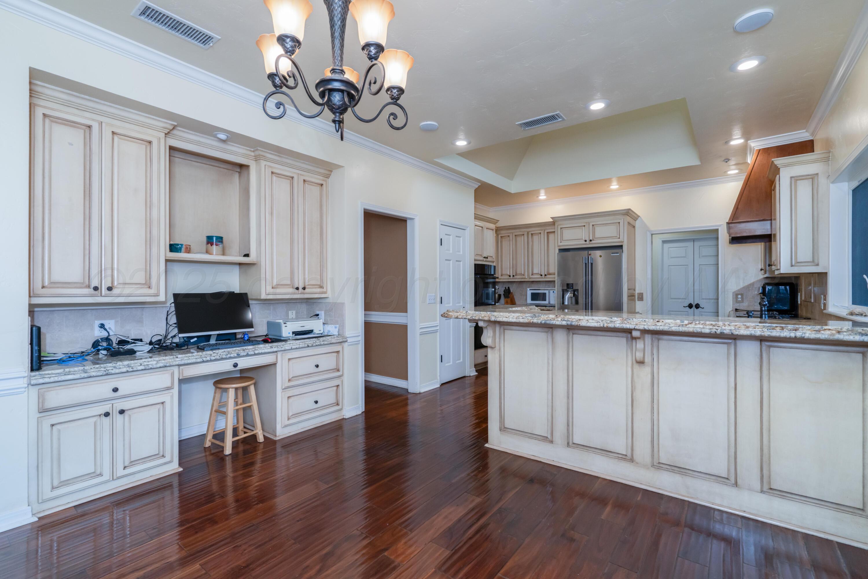 3501 Van Winkle Drive Amarillo, TX 79121 - Photo 17 of 35 a kitchen with kitchen island granite countertop a sink cabinets and wooden floor