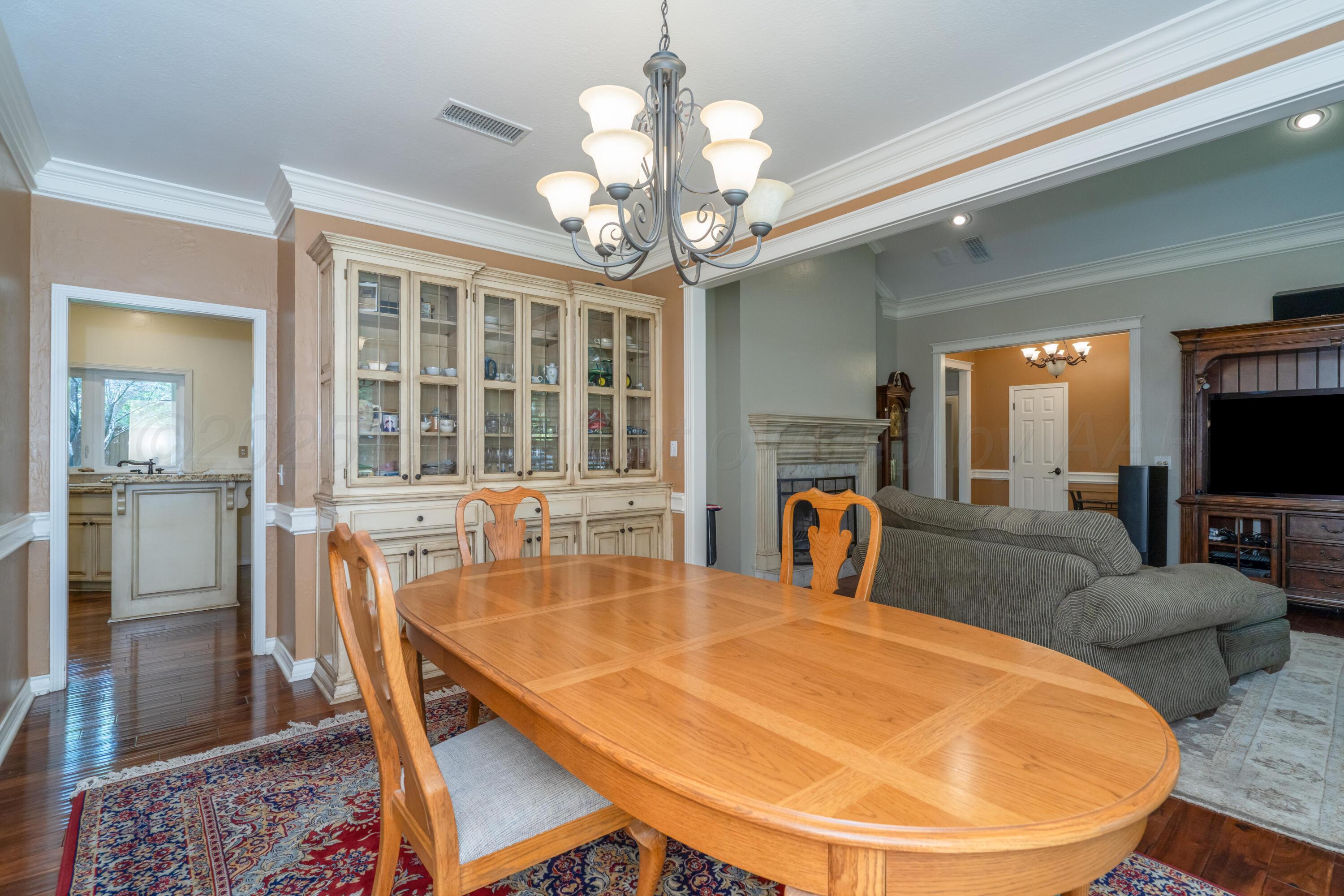 3501 Van Winkle Drive Amarillo, TX 79121 - Photo 7 of 35 a dining room with wooden floor a chandelier a wooden table and chairs