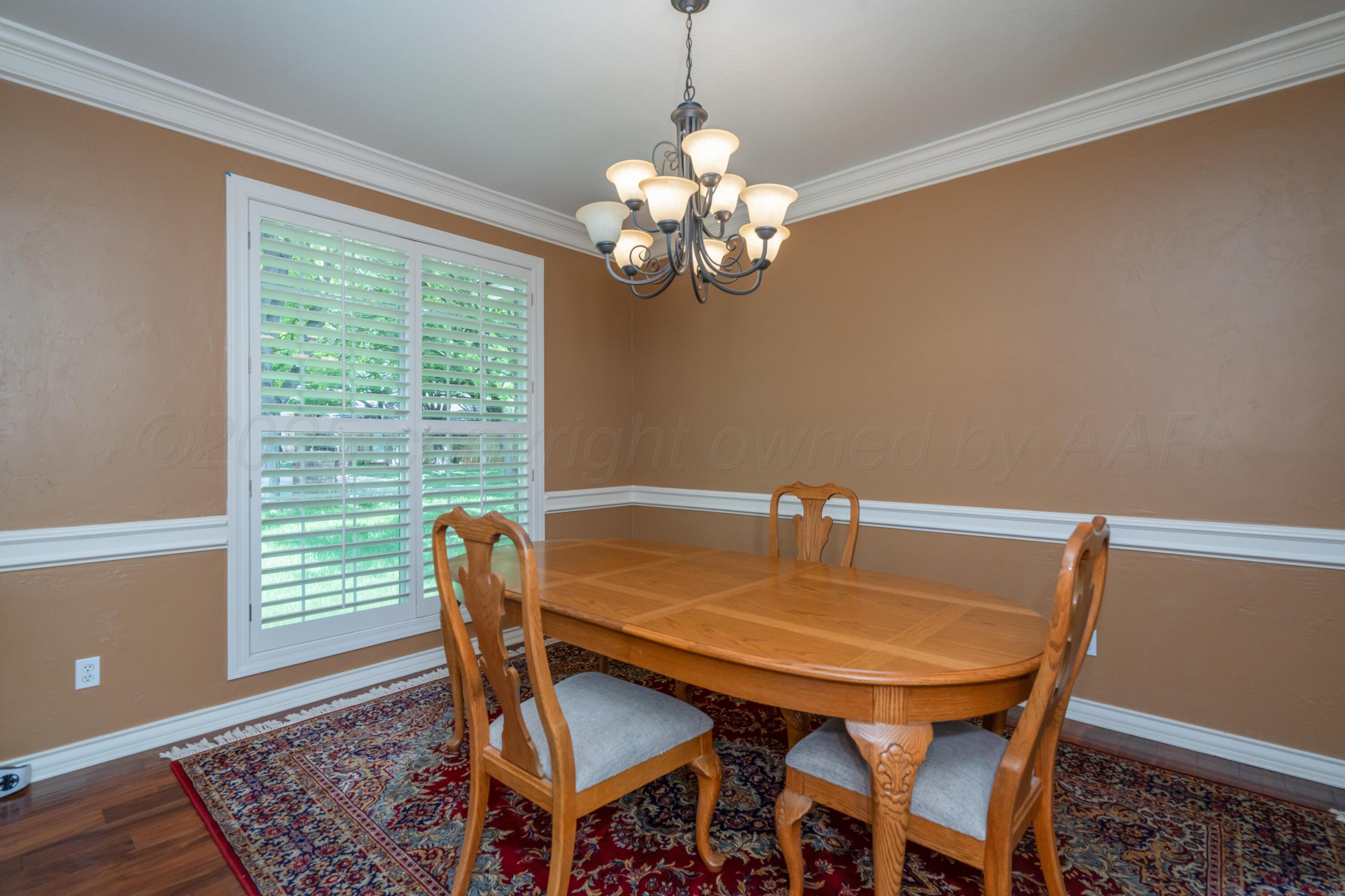 3501 Van Winkle Drive Amarillo, TX 79121 - Photo 8 of 35 a view of a dining room with furniture a chandelier and wooden floor