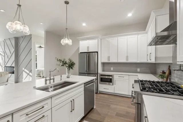 a kitchen with a sink a stove a refrigerator and cabinets