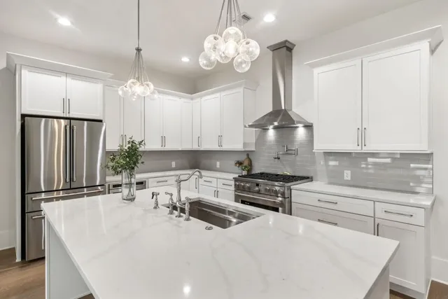 a kitchen with stainless steel appliances a stove a sink island and a refrigerator