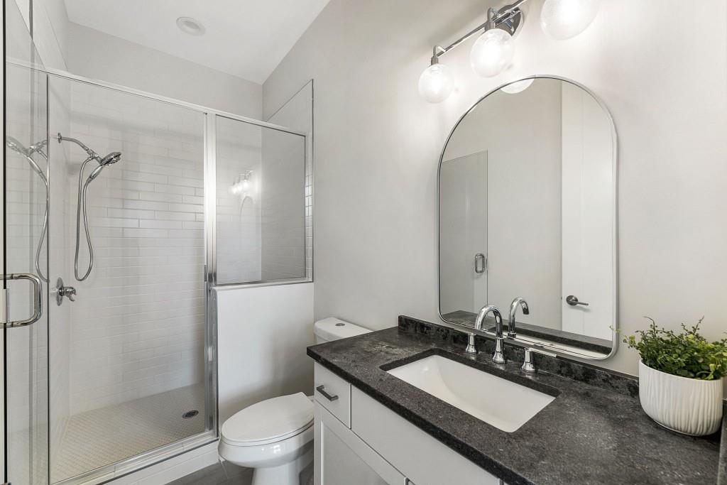 12455 Broadwell Road, Unit 202 Milton, GA 30004 - Photo 31 of 31 a bathroom with a granite countertop sink toilet and shower