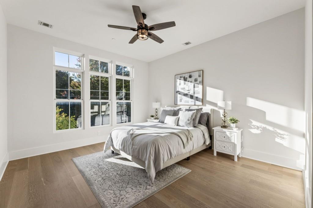 12455 Broadwell Road, Unit 202 Milton, GA 30004 - Photo 5 of 31 a spacious bedroom with a large bed a chandelier and windows
