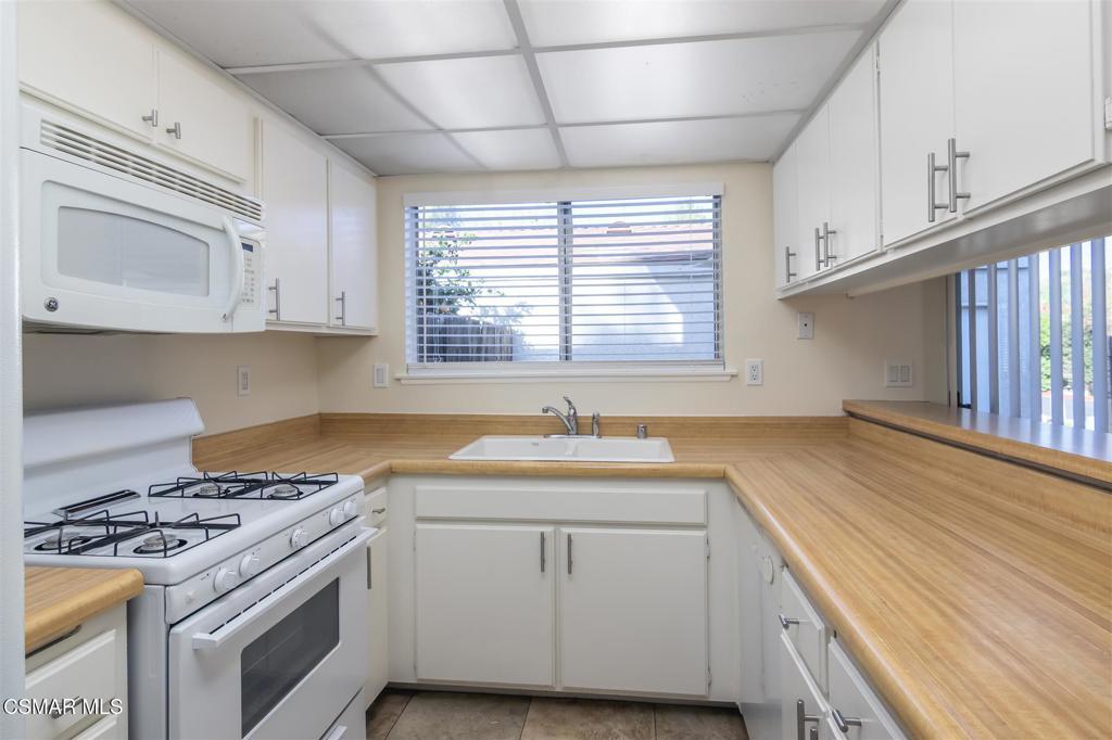 15175 Marquette Street, Unit D Moorpark, CA 93021 - Photo 6 of 22 a kitchen with granite countertop white cabinets and white appliances