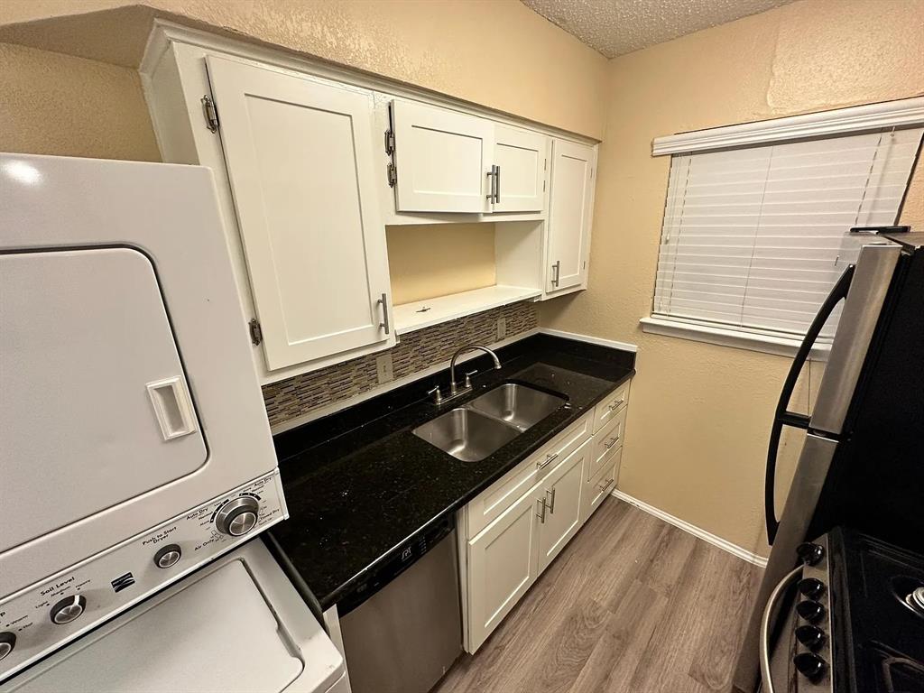 2401 Manor Road, Unit 220 Austin, TX 78722 - Photo 12 of 17 Functional workspace features modern countertops and classic wooden cabinetry alongside essential utility hookups.