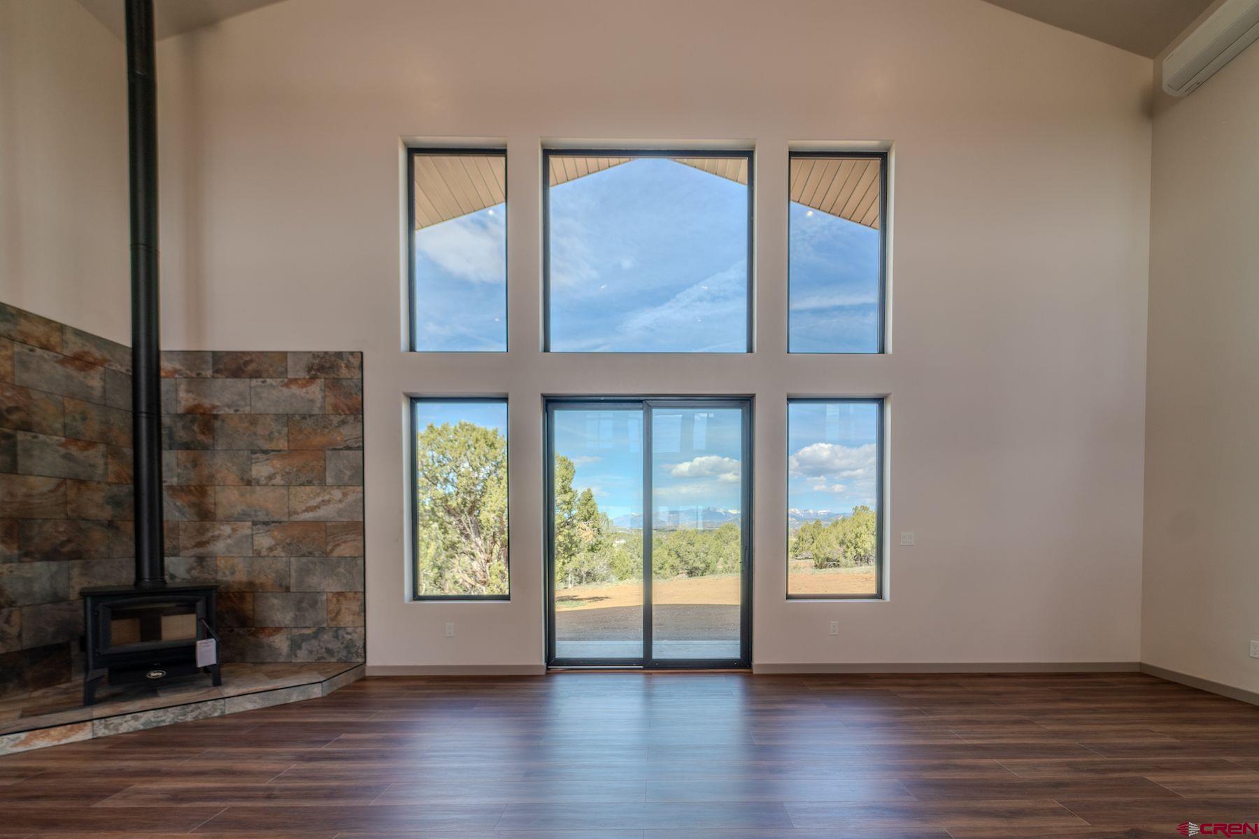 2077 Wrangler Way Durango, CO 81303 - Photo 12 of 43 an empty room with wooden floor and windows