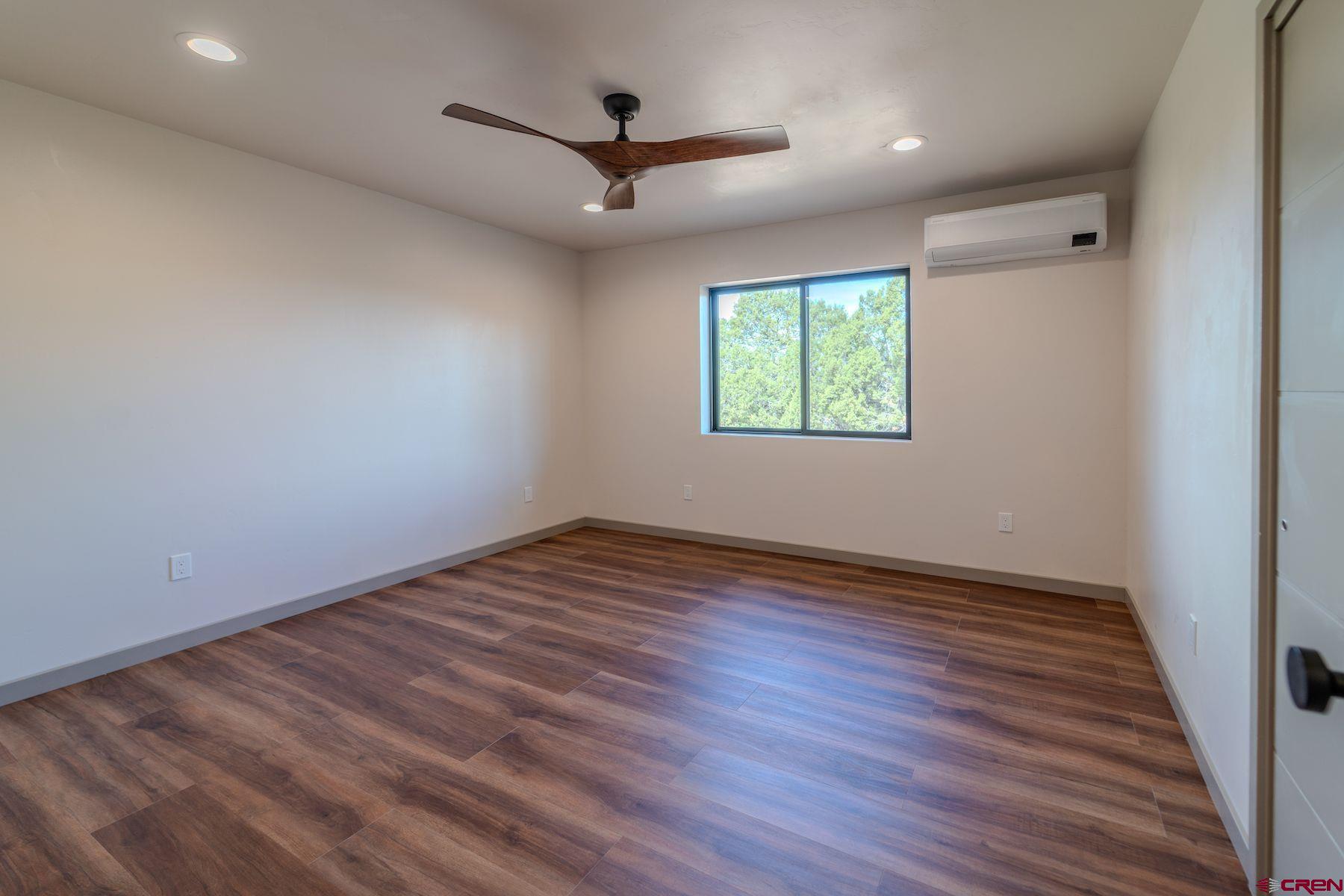 2077 Wrangler Way Durango, CO 81303 - Photo 16 of 45 an empty room with wooden floor fan and windows