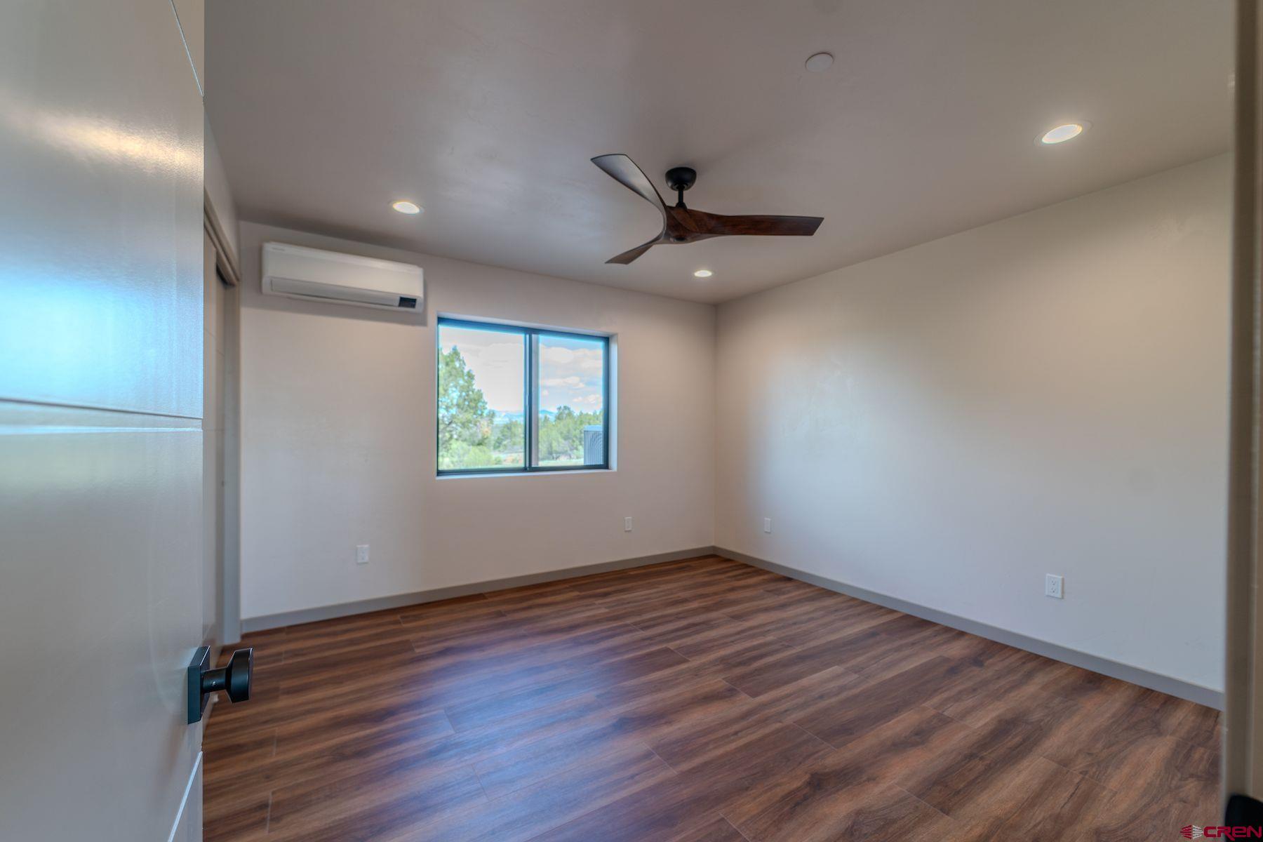 2077 Wrangler Way Durango, CO 81303 - Photo 19 of 45 an empty room with wooden floor and windows