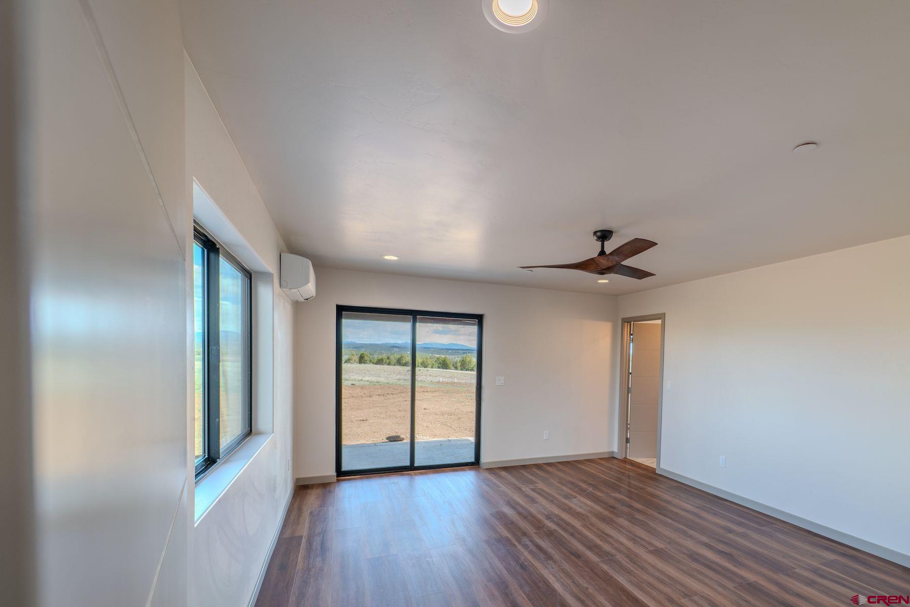 2077 Wrangler Way Durango, CO 81303 - Photo 23 of 43 an empty room with wooden floor and windows