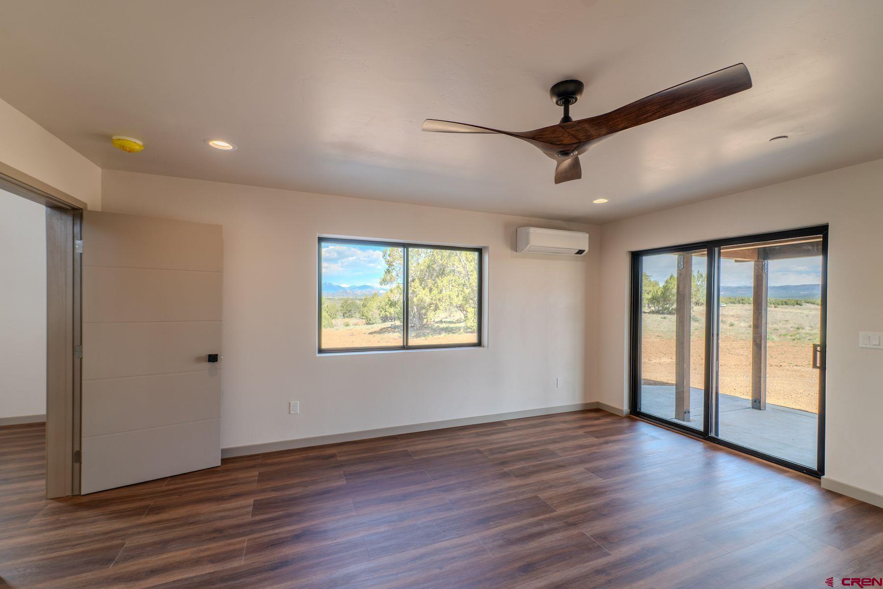 2077 Wrangler Way Durango, CO 81303 - Photo 24 of 43 a view of an empty room with wooden floor and a window