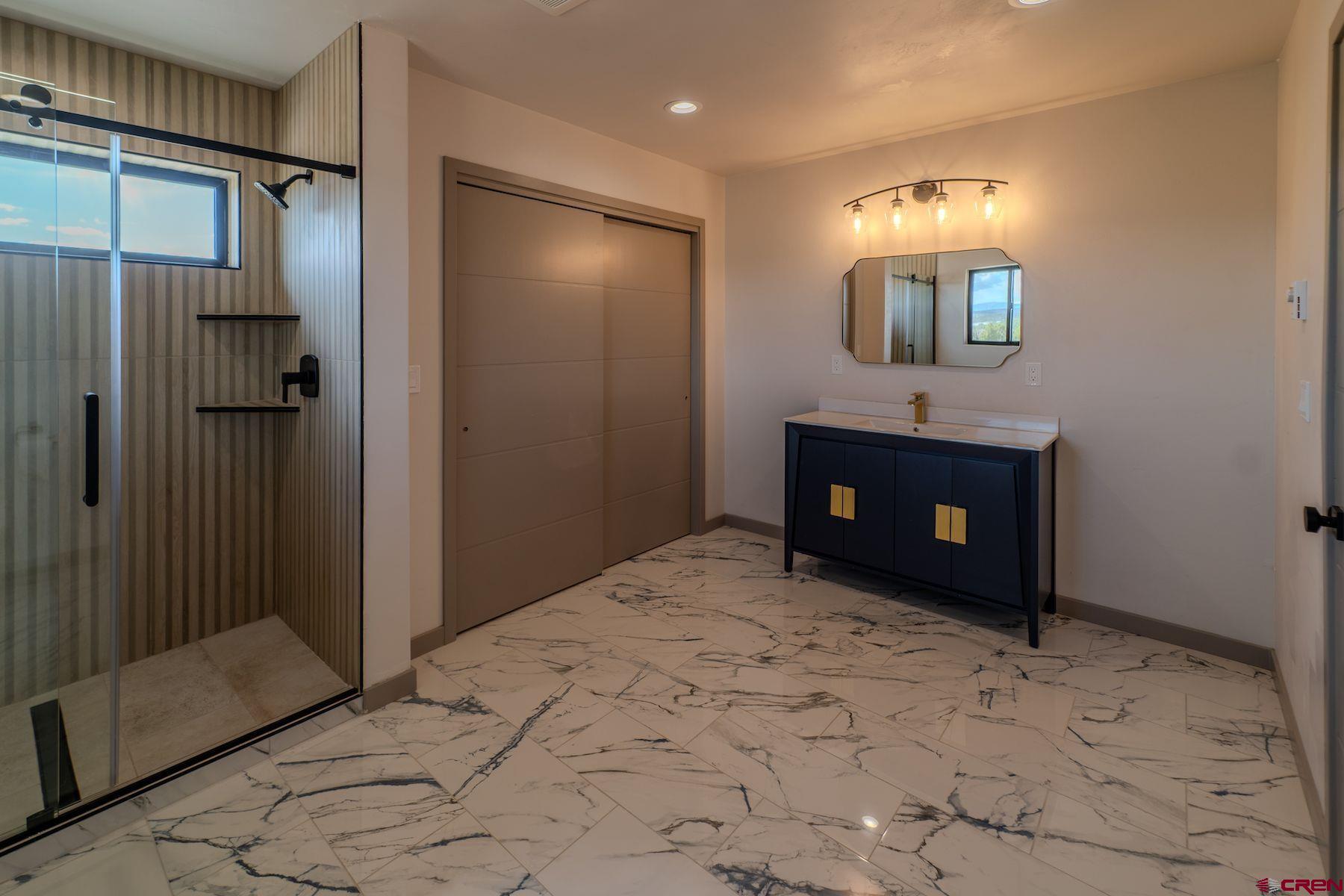 2077 Wrangler Way Durango, CO 81303 - Photo 26 of 43 a spacious bedroom with a bed and a mirror