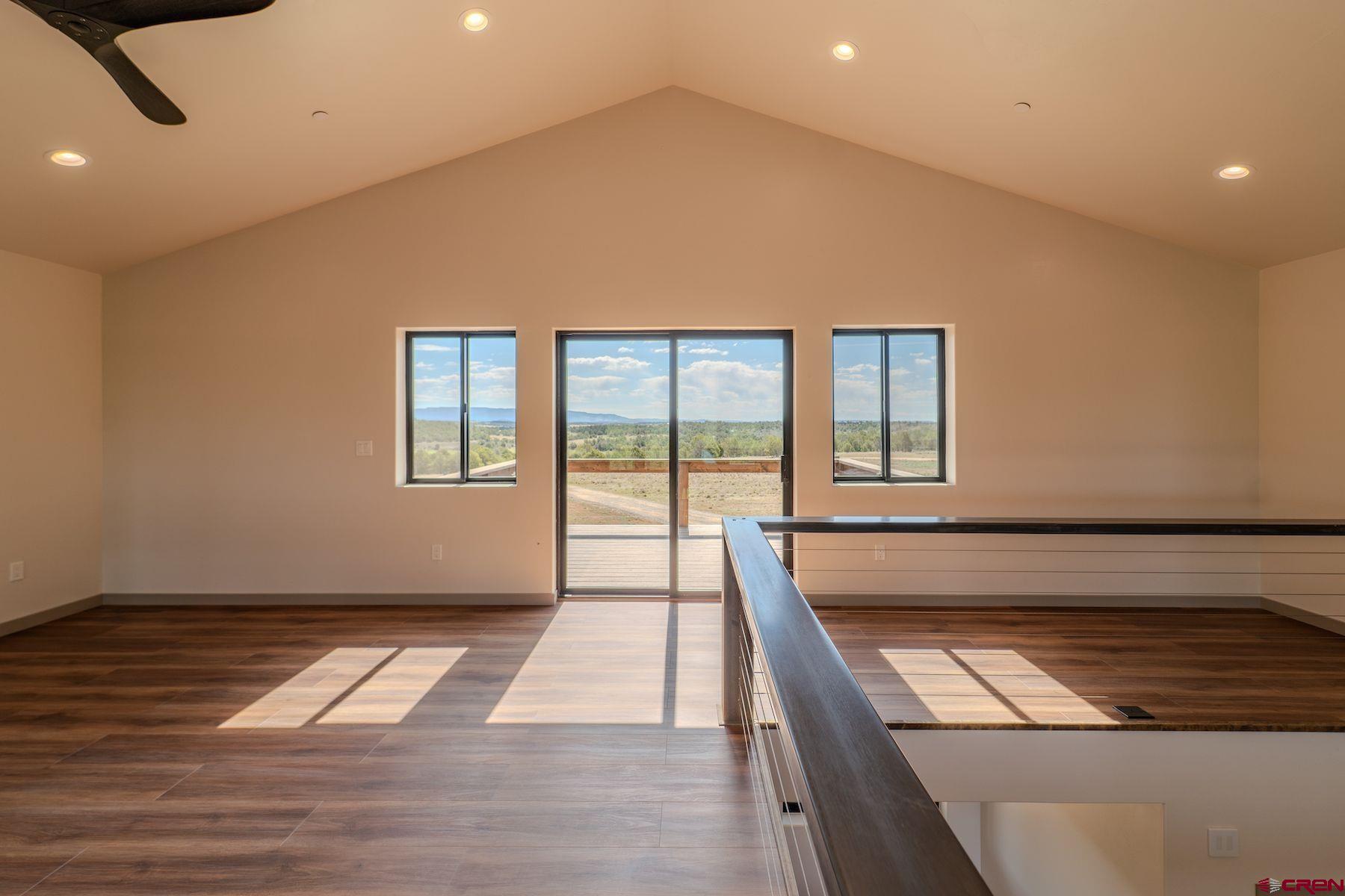 2077 Wrangler Way Durango, CO 81303 - Photo 28 of 43 a view of an empty room with wooden floor and a window