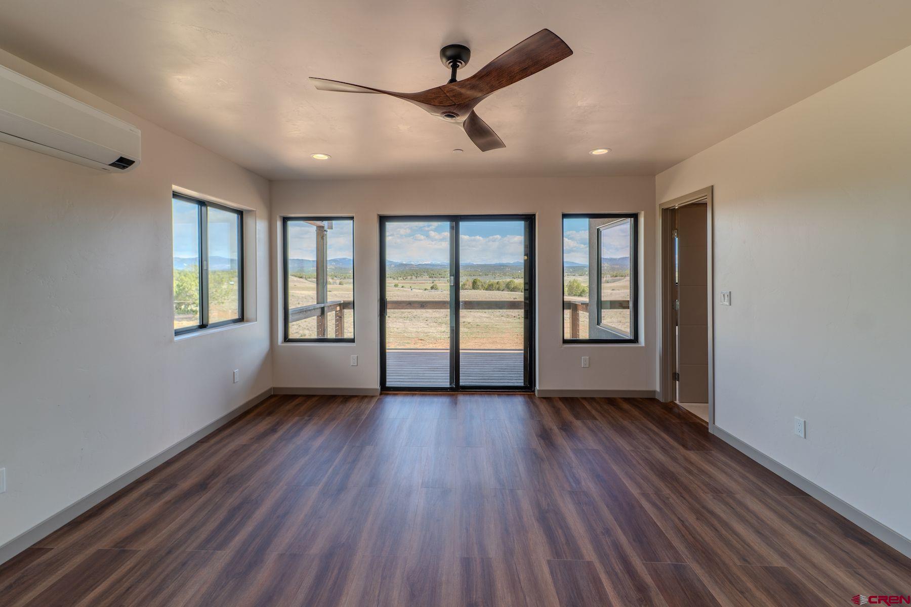 2077 Wrangler Way Durango, CO 81303 - Photo 34 of 43 a view of an empty room with a window and wooden floor