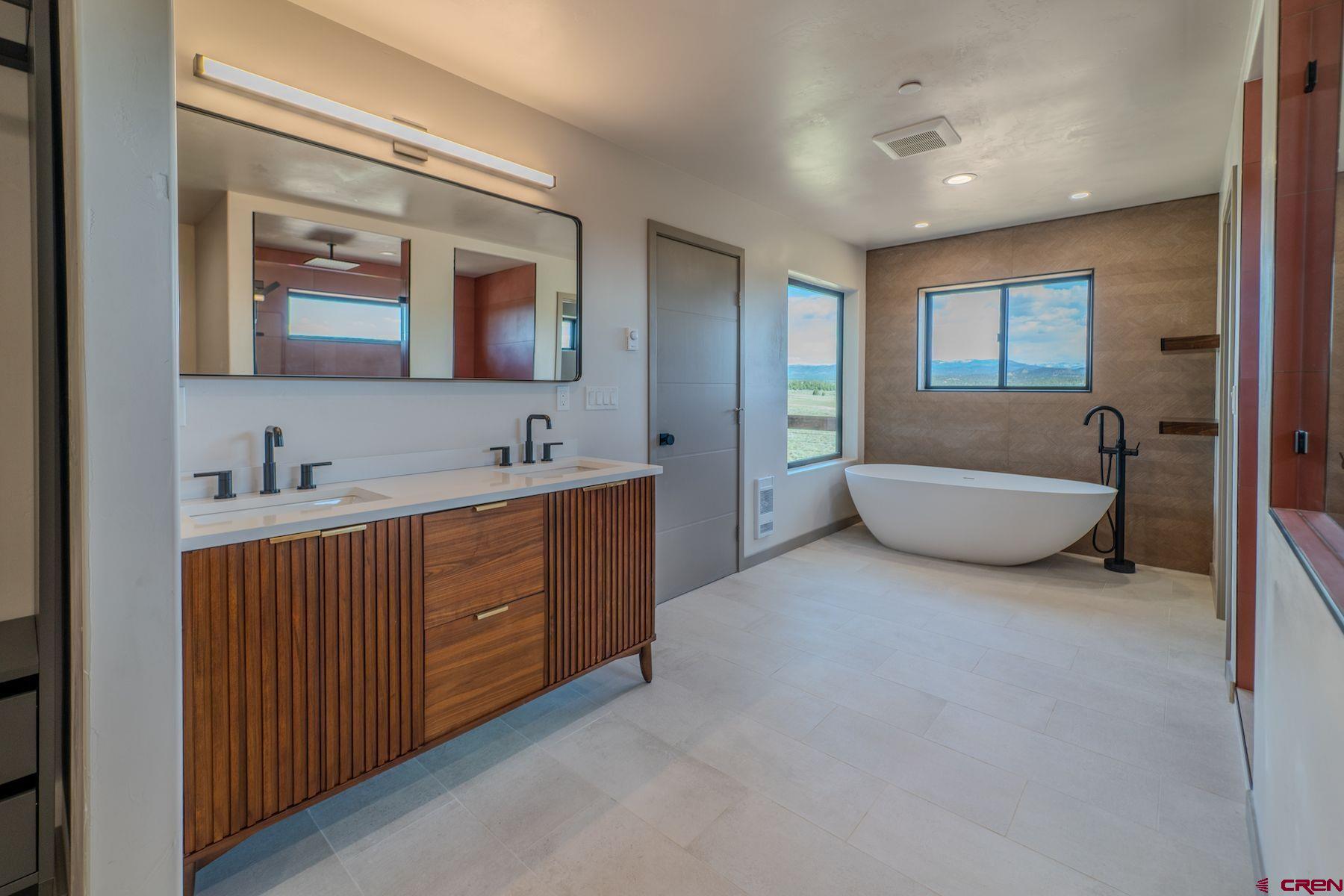 2077 Wrangler Way Durango, CO 81303 - Photo 36 of 43 a spacious bathroom with a double vanity sink a mirror and a bathtub
