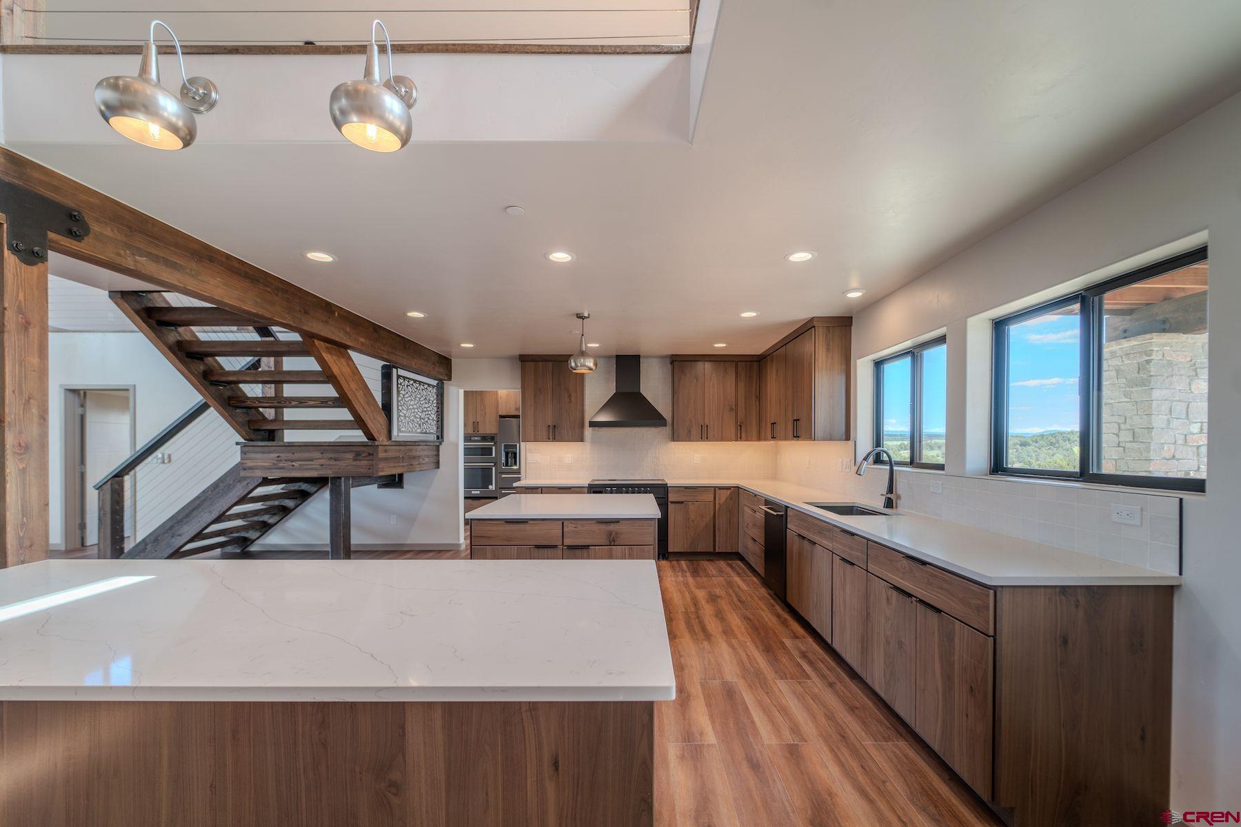 2077 Wrangler Way Durango, CO 81303 - Photo 4 of 43 a open kitchen with stainless steel appliances granite countertop a sink dishwasher a stove and a refrigerator with wooden floor