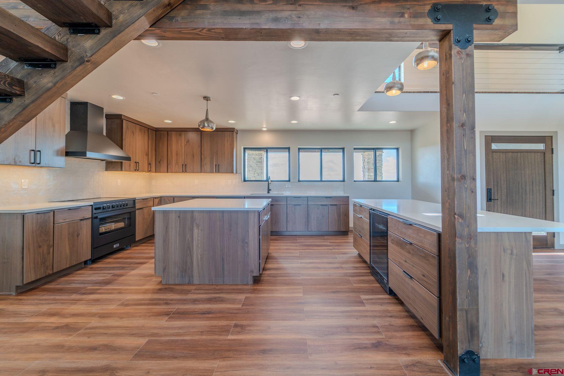 2077 Wrangler Way Durango, CO 81303 - Photo 7 of 43 a large kitchen with stainless steel appliances wooden floors and wooden cabinets