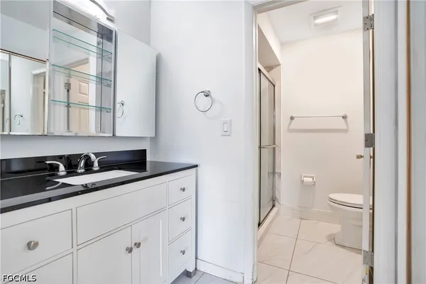 a bathroom with a granite countertop sink toilet and shower