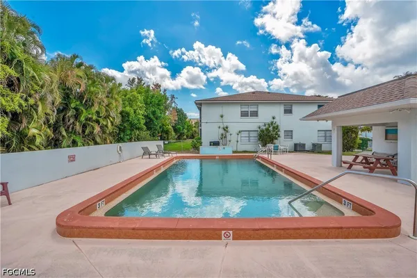 a view of a house with swimming pool and sitting area