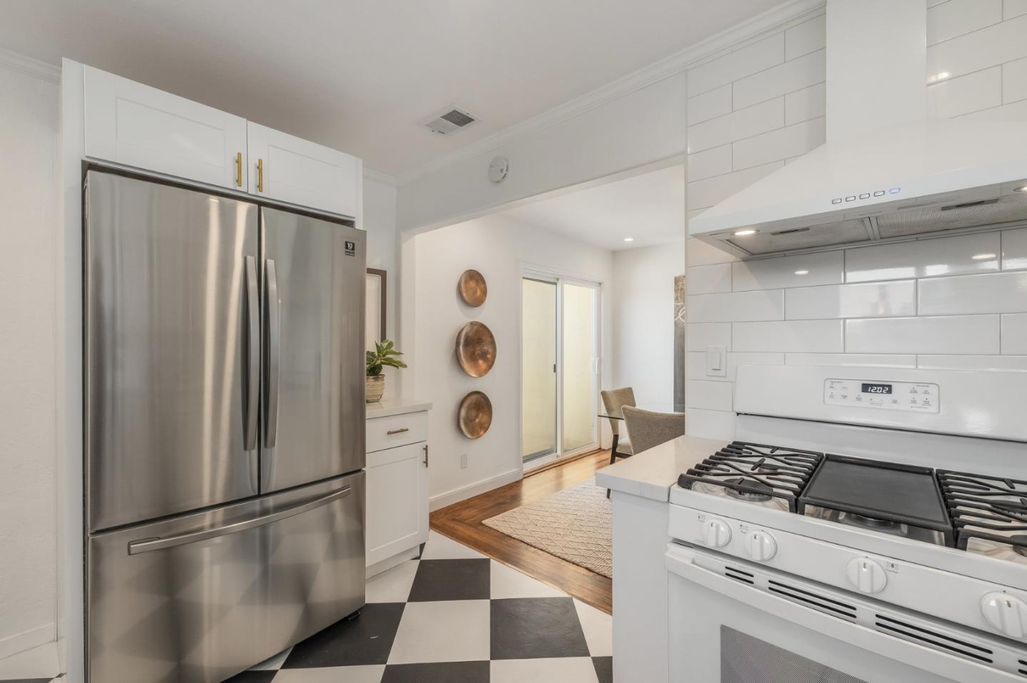 419 Millwood Drive Millbrae, CA 94030 - Photo 14 of 32 a kitchen with stainless steel appliances granite countertop a refrigerator sink and white cabinets