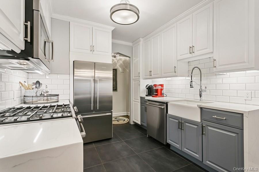 250 Bronxville Road, Unit 3I Bronxville, NY 10708 - Photo 4 of 17 a kitchen with stainless steel appliances granite countertop a sink stove and refrigerator