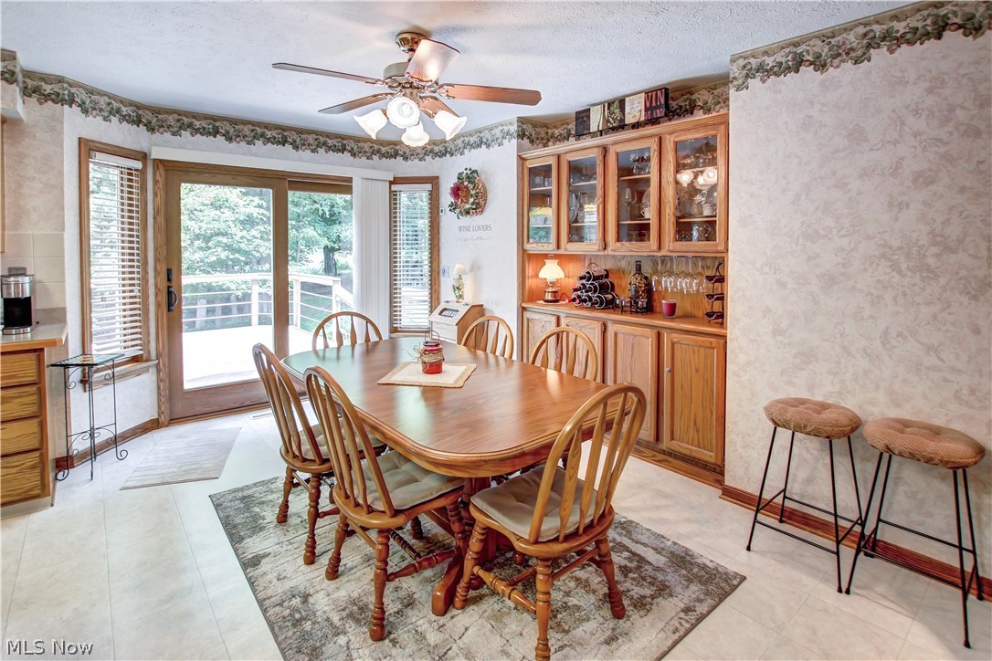 1010 Rustic Trail Cleveland, OH 44134 - Photo 7 of 49 Dining space featuring ceiling fan, plenty of natural light, light tile flooring, and a textured ceiling