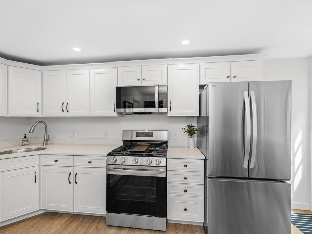 18 R Polk Street Boston, MA 02129 - Photo 4 of 19 a kitchen with white cabinets and stainless steel appliances