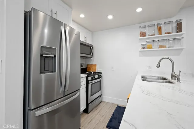 a kitchen with stainless steel appliances and refrigerator