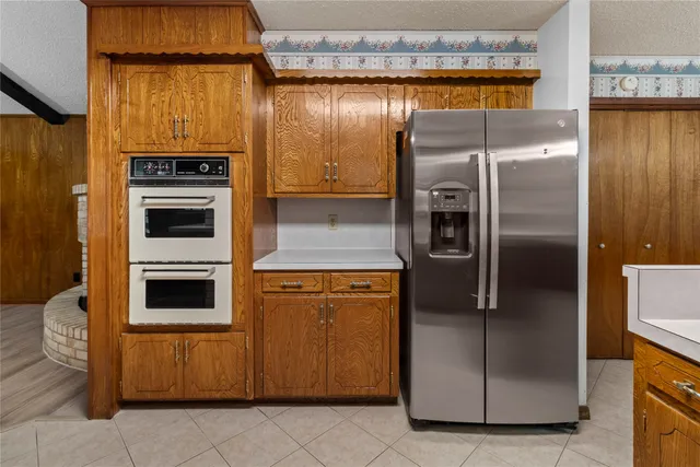 a metallic refrigerator freezer sitting in a kitchen