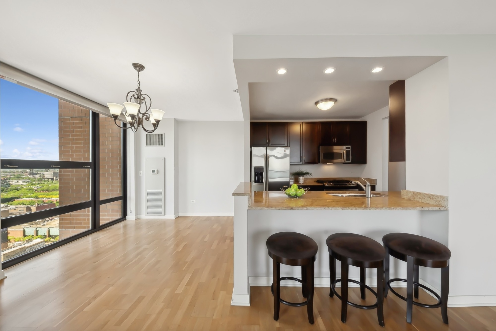 1160 South Michigan Avenue, Unit 2001 Chicago, IL 60605 - Photo 11 of 33 a kitchen with stainless steel appliances kitchen island granite countertop a table chairs and a refrigerator