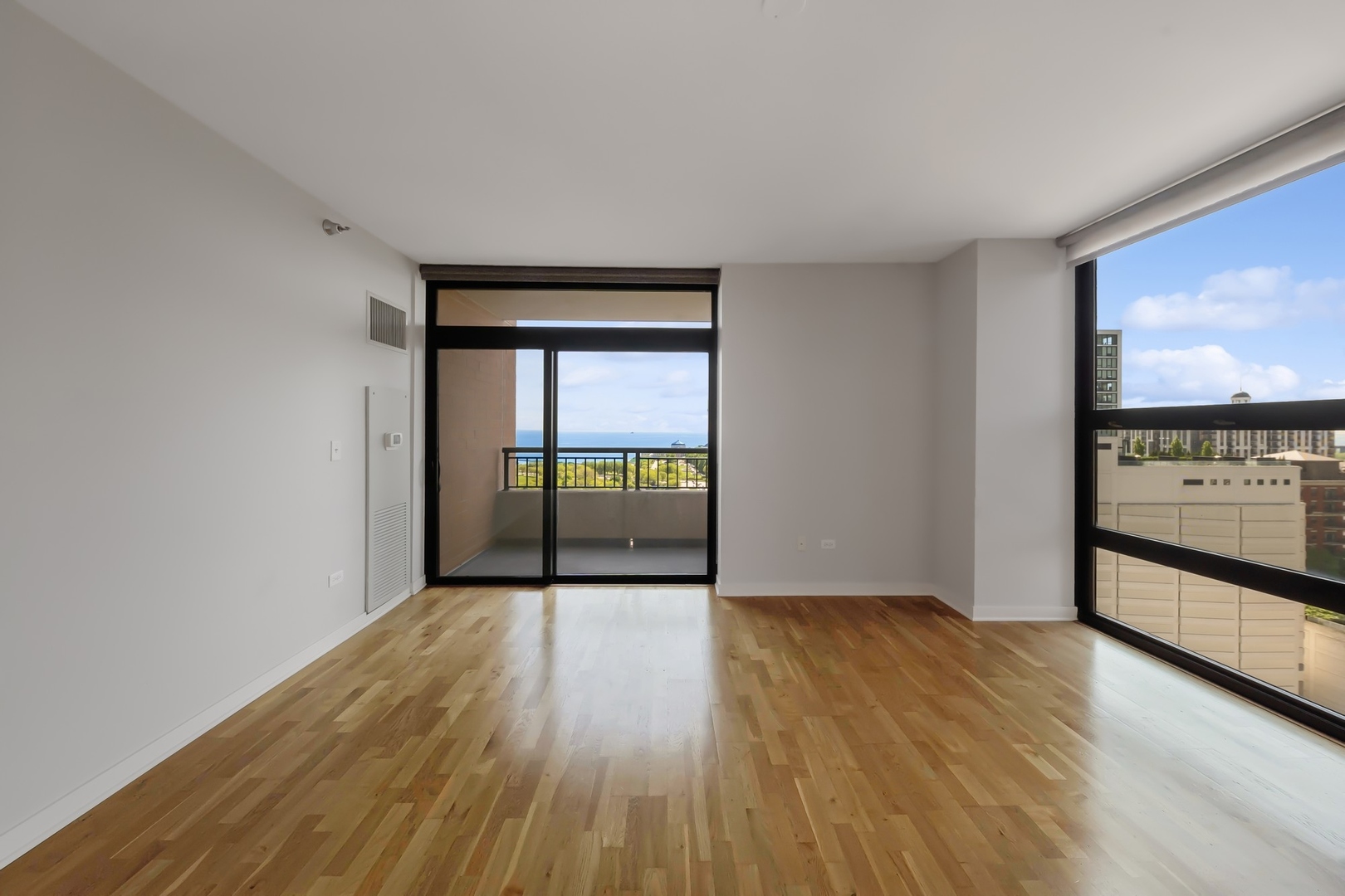 1160 South Michigan Avenue, Unit 2001 Chicago, IL 60605 - Photo 9 of 33 a view of an empty room with wooden floor and a window